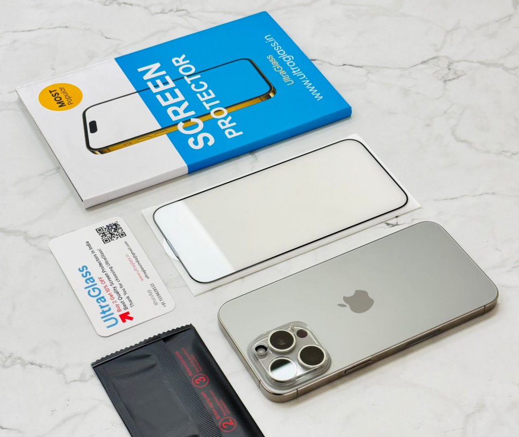 A tempered glass screen protector for iPhone 16/16Plus/16Pro/16ProMax is displayed alongside its packaging, a cleaning cloth, and a card with the brand ultraglass.in.